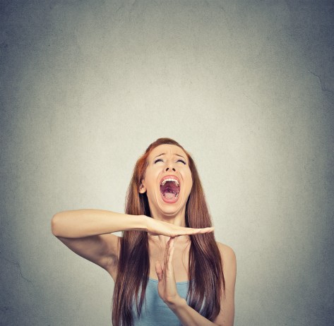 Young woman showing time out hand gesture, frustrated screaming